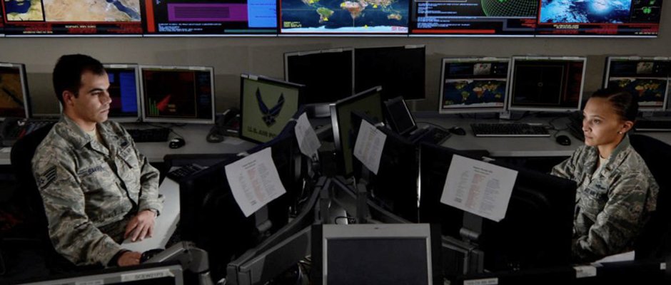 Two soldiers watching computer screens